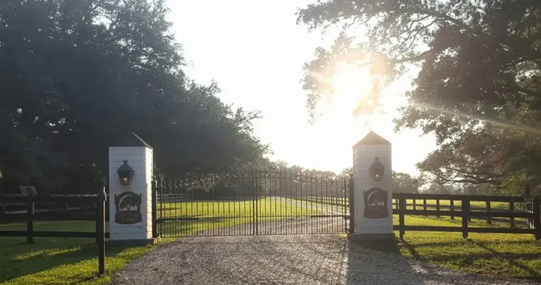 Custom driveway gate and brick columns at golden hour
